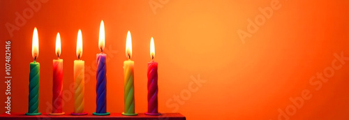 Happy Kwanzaa holiday banner, greeting card.  African American New Year festival, multicolored burning candles on  orange background, copy space. photo