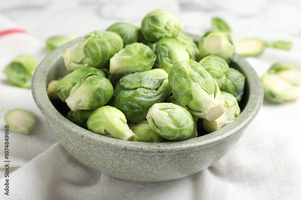 Fresh Brussels sprouts in bowl on white table, closeup Fresh Brussels sprouts in bowl on white table, closeup