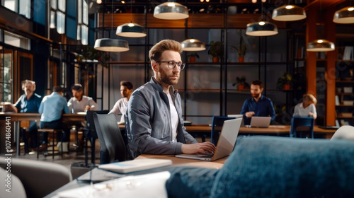 Professional coworking space with focused man on laptop