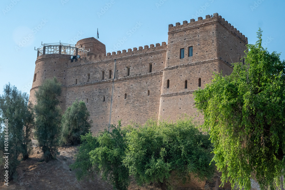 A large castle sits atop a hill, surrounded by trees and greenery, Shush, Iran A large castle sits atop a hill, surrounded by trees and greenery, Shush, Iran