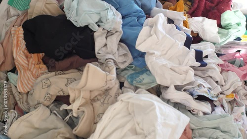 Dust particles floating in the air in front of a big pile of laundry lying on a couch
