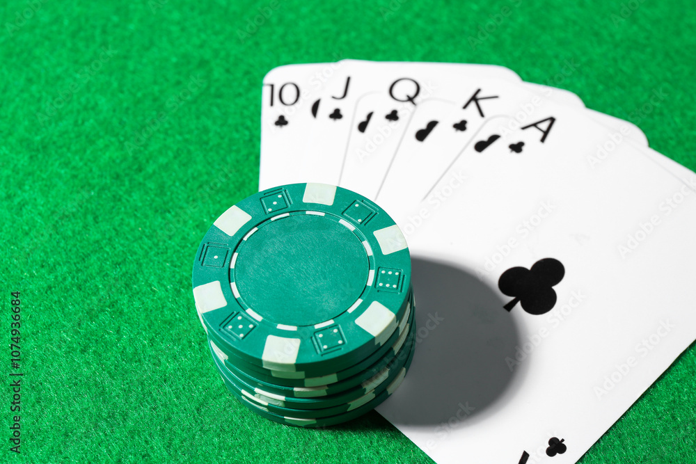 Fototapeta premium Playing cards and poker chips on green table, closeup