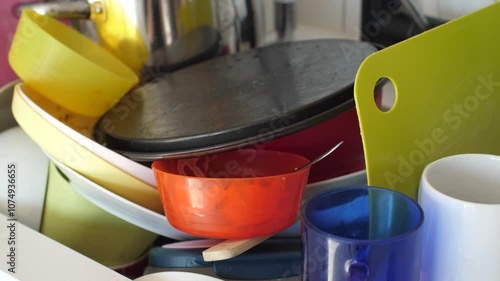 Close up view of a sink full of dirty dishes, cluttered home kitchen