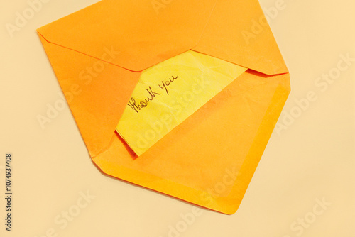 THANK YOU note on orange envelope paper