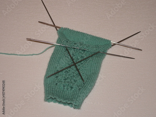 The sock is knitted on five needles photo