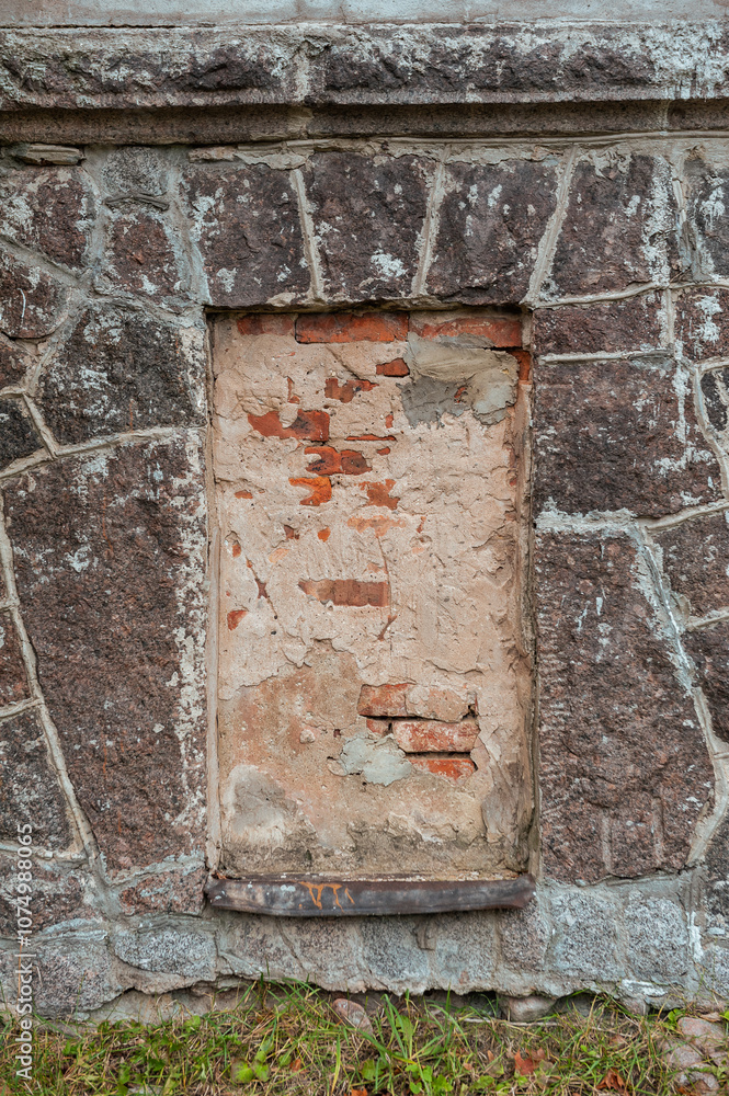 Weathered brick and stone wall with walled up window showcasing rustic texture Weathered brick and stone wall with walled up window showcasing rustic texture
