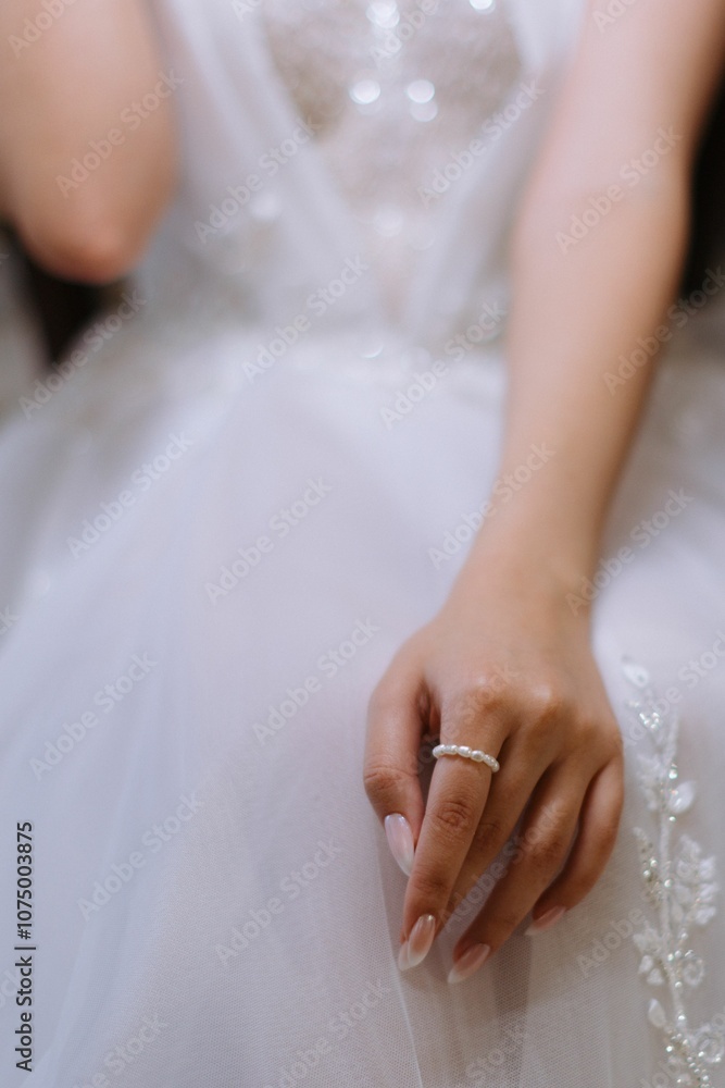 Bride's hand with pearl ring on lace dress. Bride's hand with pearl ring on lace dress.