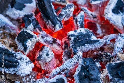 Glowing Hot Charcoal Embers with Vibrant Red Heat and White Ash in Extreme Close-up. Burning Wood Coals Create Abstract Patterns of Fire and Cinders in Dramatic Macro Photography photo