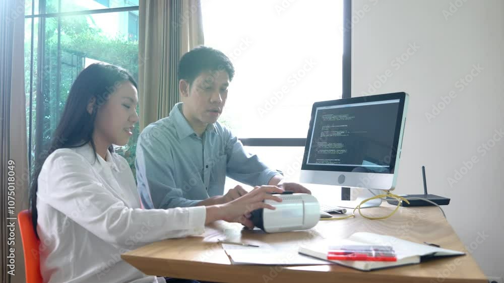 A woman is sitting at a desk with a computer monitor in front of her. She is typing on the keyboard and she is focused on her work A woman is sitting at a desk with a computer monitor in front of her. She is typing on the keyboard and she is focused on her work