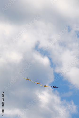 Propeller plane in formation flight in the sky among the clouds photo