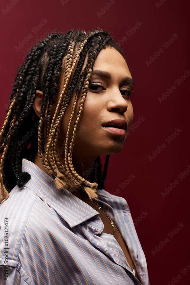 A fashionable young woman with braided hair strikes a pose against a rich backdrop, showcasing her unique style. A fashionable young woman with braided hair strikes a pose against a rich backdrop, showcasing her unique style.