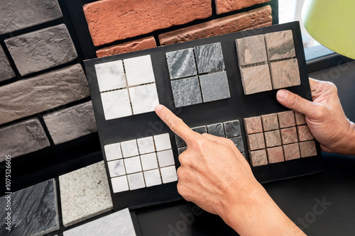 Canvas Print Architect hand pointing at stone tile collection display on sample board