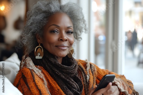 Portrait of a stylish senior woman using a phone in a cafe photo