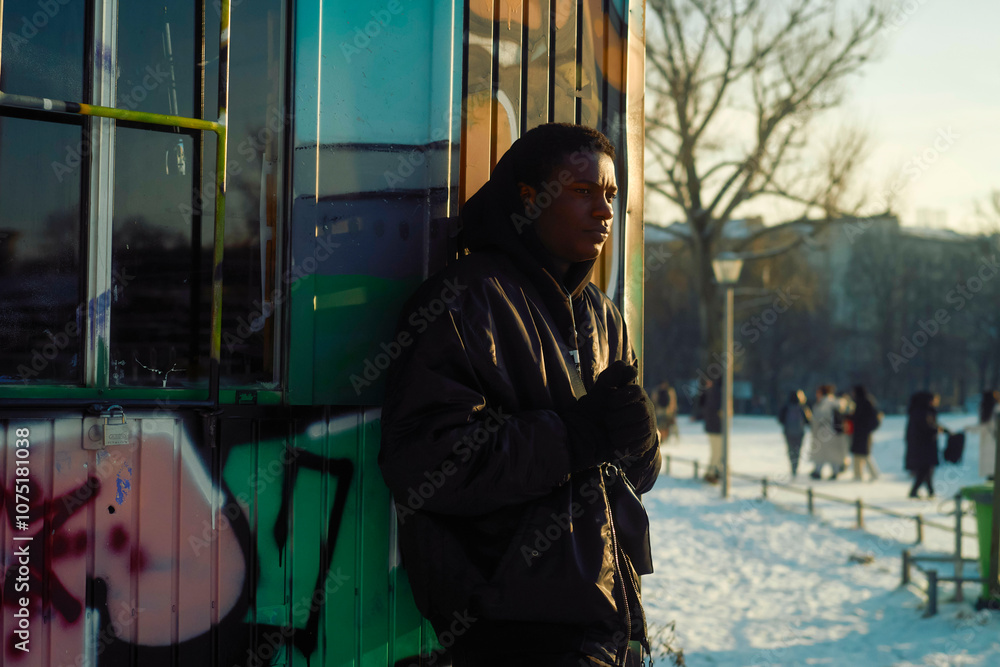 Young Man standing beside a graffiti-covered hut in a public park on a snowy day, Berlin, Germany Young Man standing beside a graffiti-covered hut in a public park on a snowy day, Berlin, Germany
