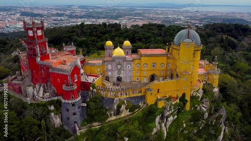 Famous National Palace of Pena situated in Sintra, Portugal. Drone going backward. The castle stands on the top of a hill in the Sintra Mountains above the town.