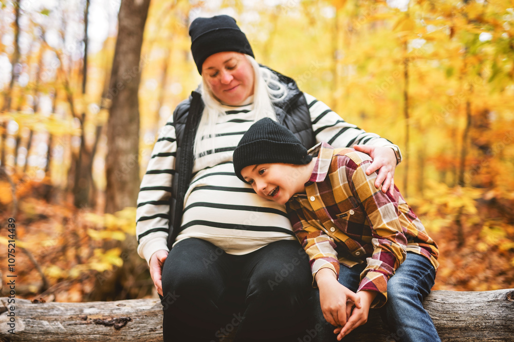 Joyful pregnant mother and his little boy. mother and child have fun on nature outdoors at autumn park.
