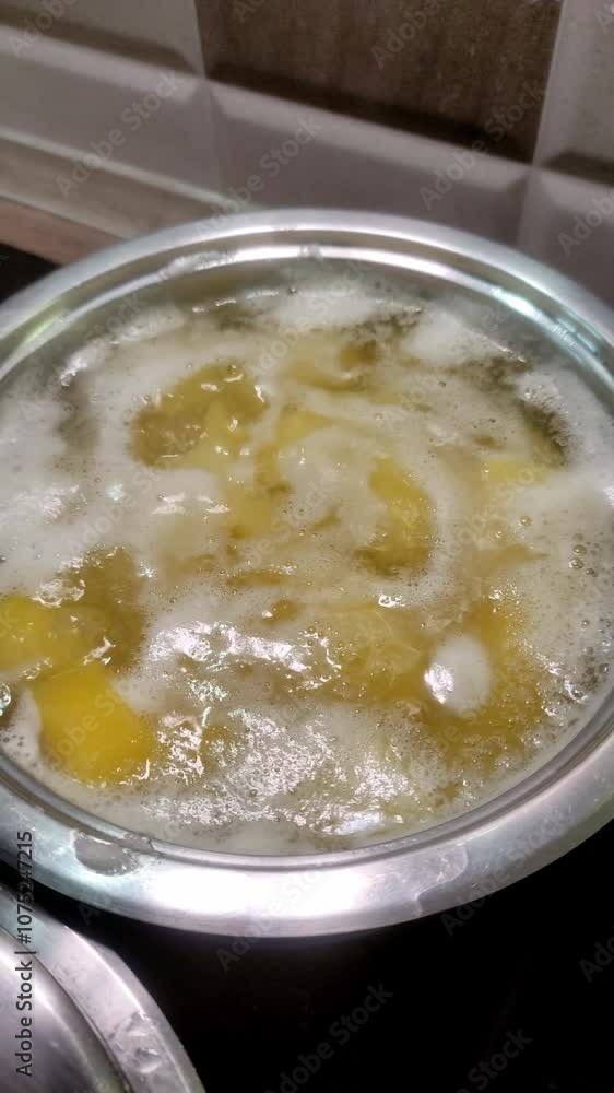 Raw potatoes are boiled in a saucepan Raw potatoes are boiled in a saucepan