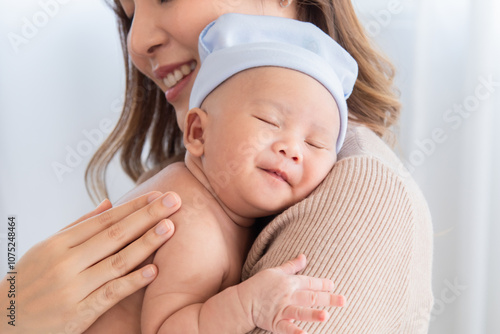 Adorable sleeping baby in mother arm or chest, breastfeeding nursing healthcare, young Asian beautiful woman hold infant 0-1 month with love, gently, tenderly, cuddle, bonding, mom and newborn caring photo