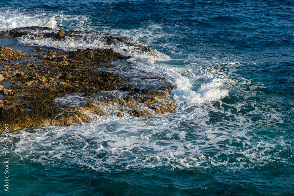 Waves crash against rocky shoreline during golden hour at a serene coastal beach location. Waves crash against rocky shoreline during golden hour at a serene coastal beach location.