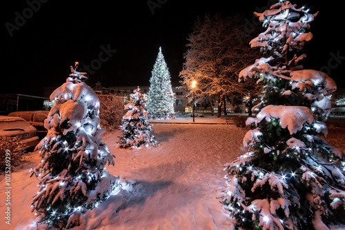 Christmas tree with lights in the town in the evening atmosphere with snow cover photo