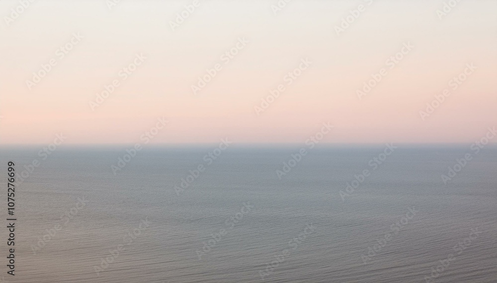 A serene seascape with a delicate pink sky at sunset. A serene seascape with a delicate pink sky at sunset.