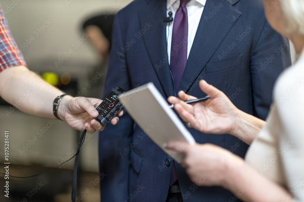 © wellphoto - Journalists gather information with audio recorder and notepad in professional interview setting for media coverage © wellphoto - Journalists gather information with audio recorder and notepad in professional interview setting for media coverage