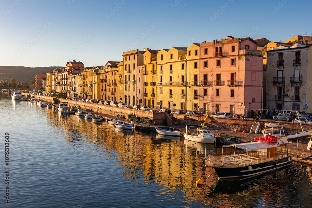 Fototapeta premium Panoramic view of the picturesque town of Bosa with its colorful houses reflected in the Temo River at golden hour. Sardinia, Italy.
