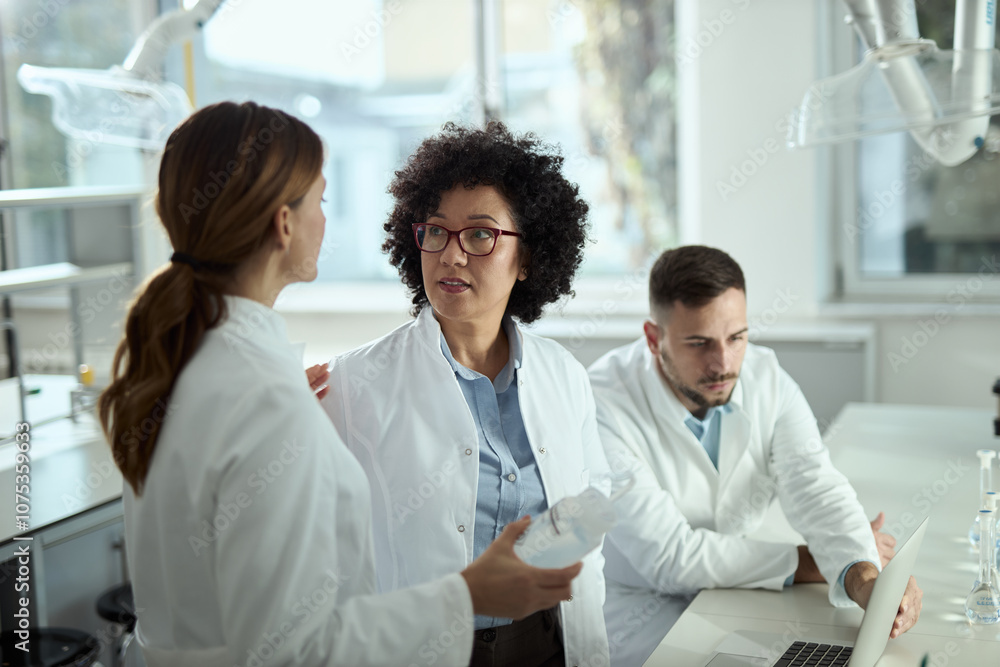 Female scientists talking while working together in laboratory. Female scientists talking while working together in laboratory.