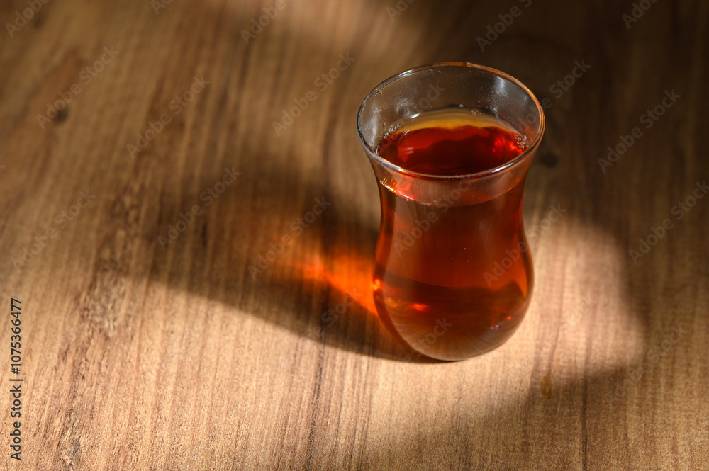 Warm tea resting on a wooden table as sunlight creates gentle shadows in a cozy setting Warm tea resting on a wooden table as sunlight creates gentle shadows in a cozy setting