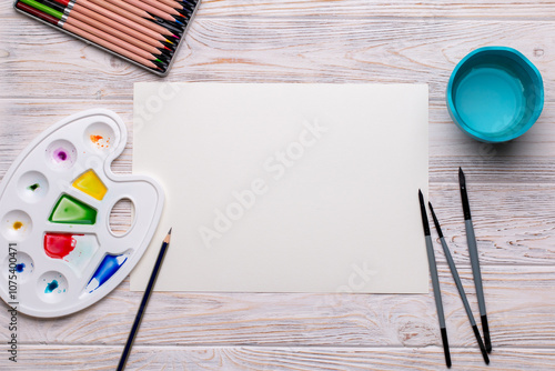 Top View of Blank Canvas with Art Supplies on White Wooden Table