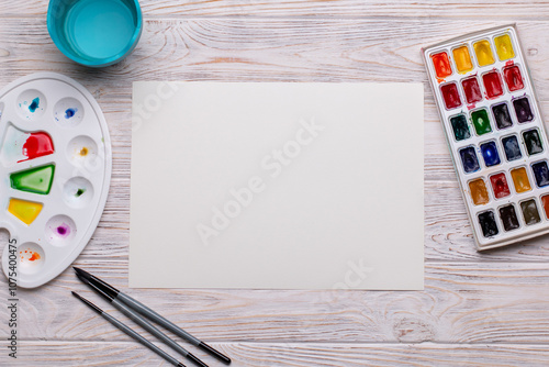 Top View of Blank Canvas with Art Supplies on White Wooden Table