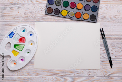 Top View of Blank Canvas with Art Supplies on White Wooden Table