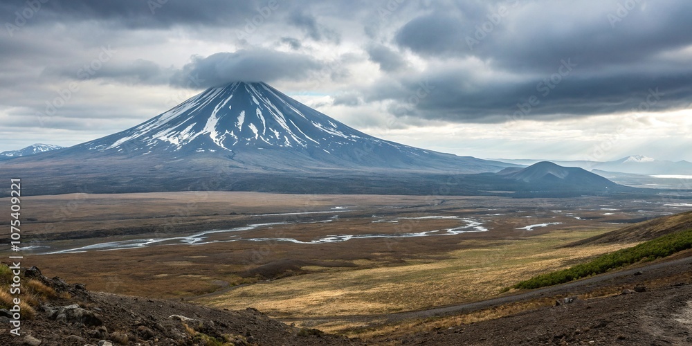 The summit of a dormant volcano rises above the surrounding landscape on the Kamchatka Peninsula, dormant volcano, adventure, natural wonder The summit of a dormant volcano rises above the surrounding landscape on the Kamchatka Peninsula, dormant volcano, adventure, natural wonder