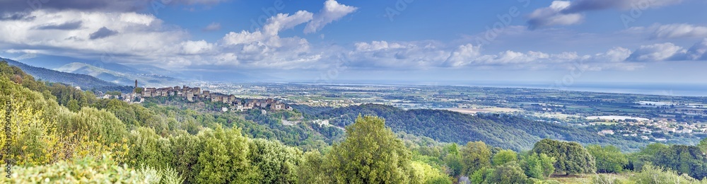 Panoramic view of a traditional Corsican mountain village with the vast eastern coastline in the distance Panoramic view of a traditional Corsican mountain village with the vast eastern coastline in the distance