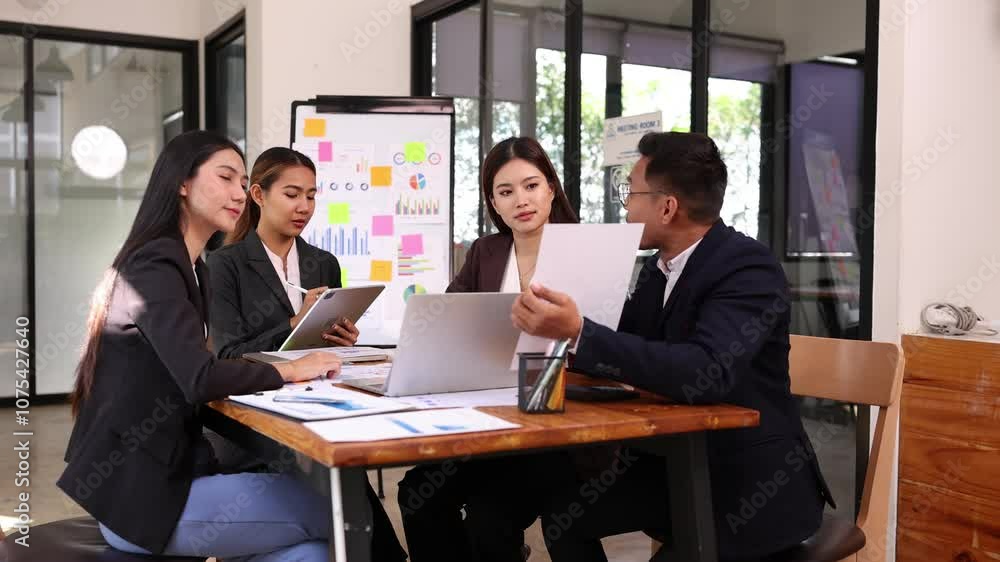 Asian group of people working with documents have financial or marketing charts on a board room at a business presentation or seminar, Business training meeting and business sales. Asian group of people working with documents have financial or marketing charts on a board room at a business presentation or seminar, Business training meeting and business sales.