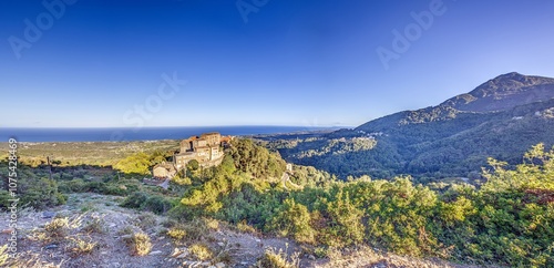 Panoramic view of a traditional Corsican mountain village with the vast eastern coastline in the distance