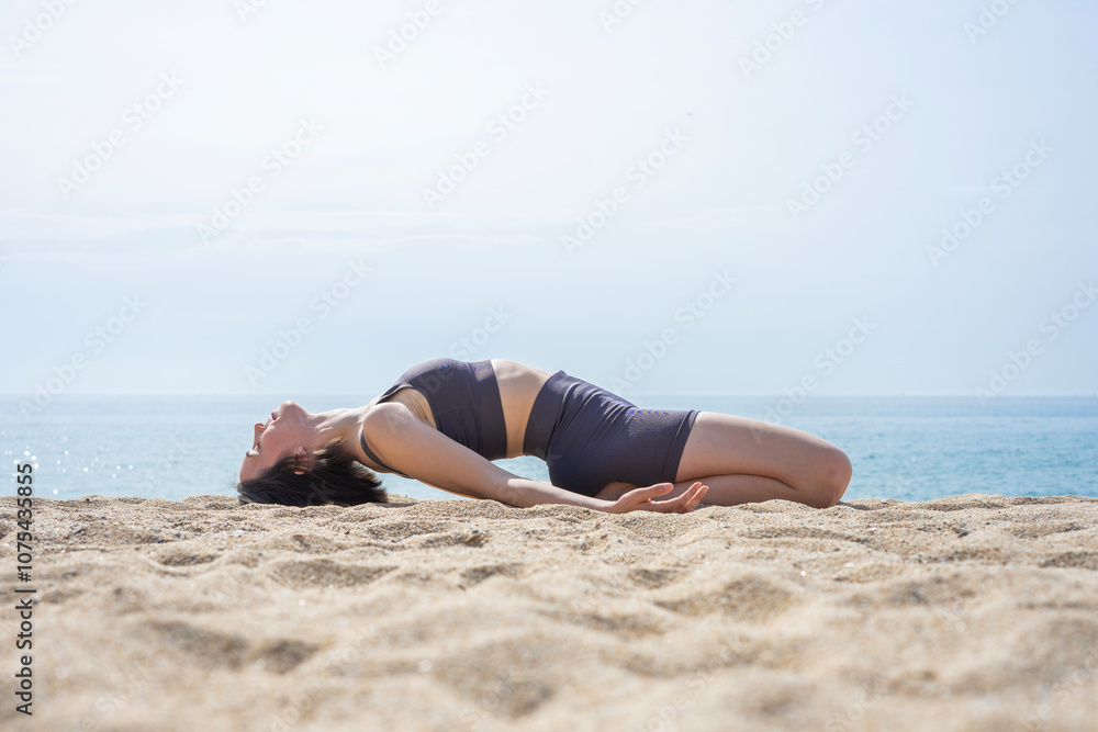a woman doing yoga on the beach in front of the ocean. Saddle pose. Copy space. a woman doing yoga on the beach in front of the ocean. Saddle pose. Copy space.
