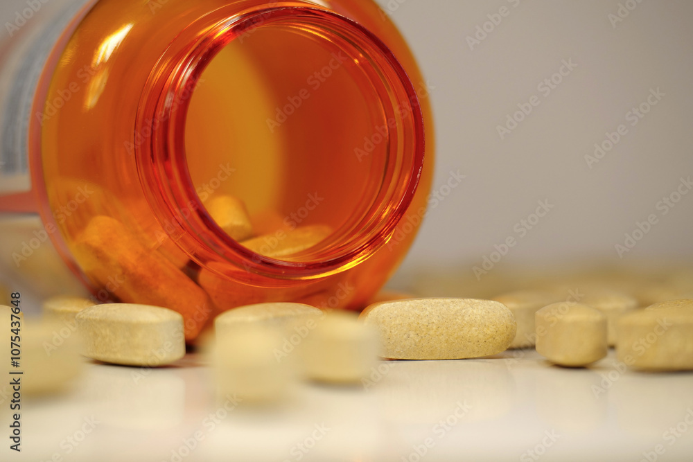 Big yellow pills and open orange jar on table. In reality these are vitamin C Big yellow pills and open orange jar on table. In reality these are vitamin C