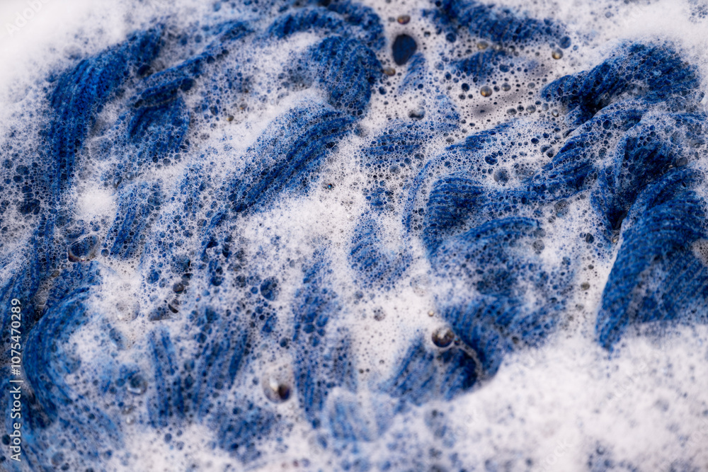 Obraz premium Blue Wool Sweater Being Hand Washed in Soapy Water