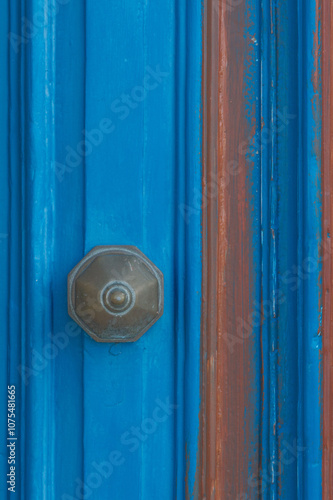 Detail of a blue door with a knob, close up.