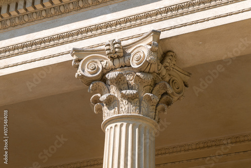 A close-up of a Corinthian column capital, showing intricate acanthus leaf designs and volutes.