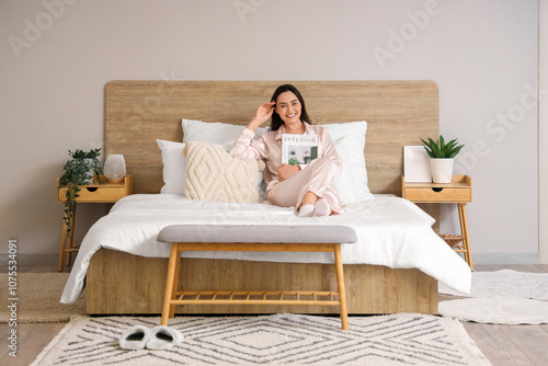 Young woman in pajamas read...