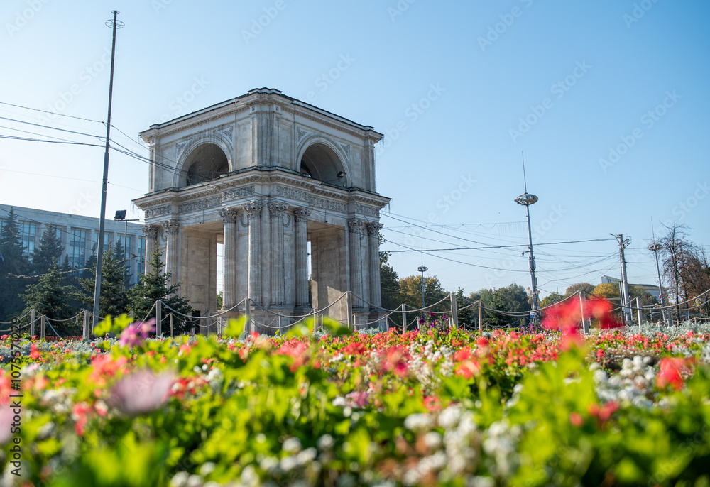 Triumphal Arch in city center of Chisinau Moldova. Flowers in Chisinau.