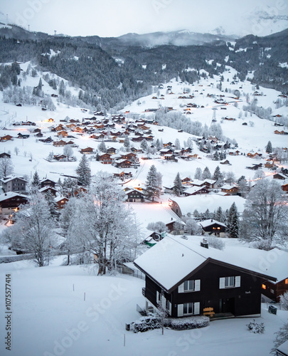 Grindelwald, under the soft glow of the night lights, transforms into a magical village where the snow glistens and each chalet seems to watch over the peaceful, slumbering mountains, Switzerland.