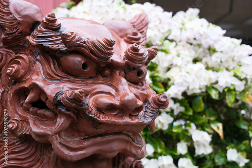 沖縄県那覇市の風景。シーサーと南国の花