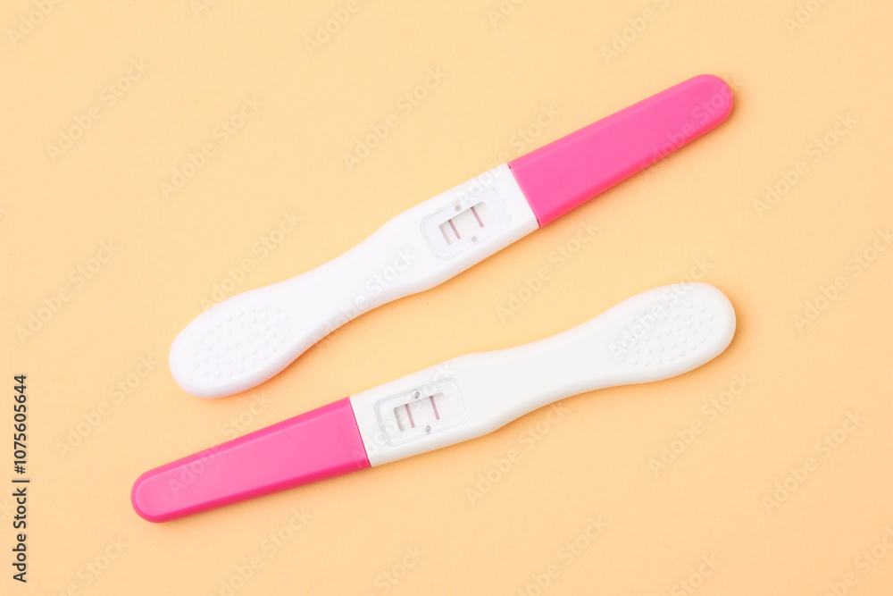 Pregnancy tests on pale orange background, above view Pregnancy tests on pale orange background, above view