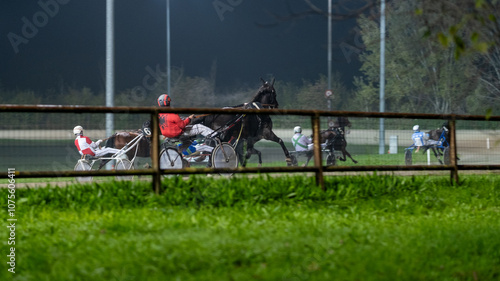 Racing horses trots and rider on a track of stadium. Competitions for trotting horse racing. Horses compete in harness racing. Horse runing at the track with rider.
 photo