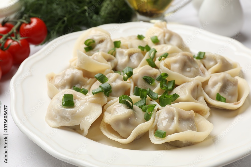 Delicious pelmeni with green onion on white table, closeup Delicious pelmeni with green onion on white table, closeup