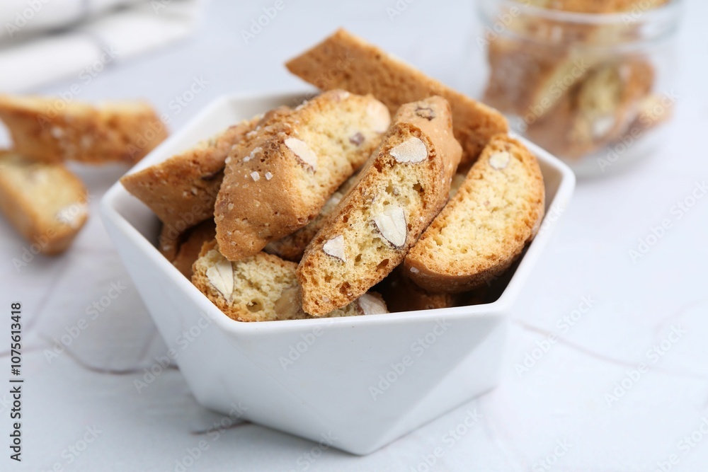 Traditional Italian almond biscuits (Cantucci) in bowl on white table, closeup Traditional Italian almond biscuits (Cantucci) in bowl on white table, closeup