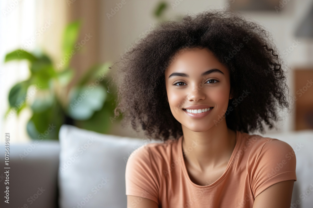 A young woman with curly hair smiles warmly while sitting on a couch in a cozy, sunlit living room surrounded by greenery. Generative AI A young woman with curly hair smiles warmly while sitting on a couch in a cozy, sunlit living room surrounded by greenery. Generative AI